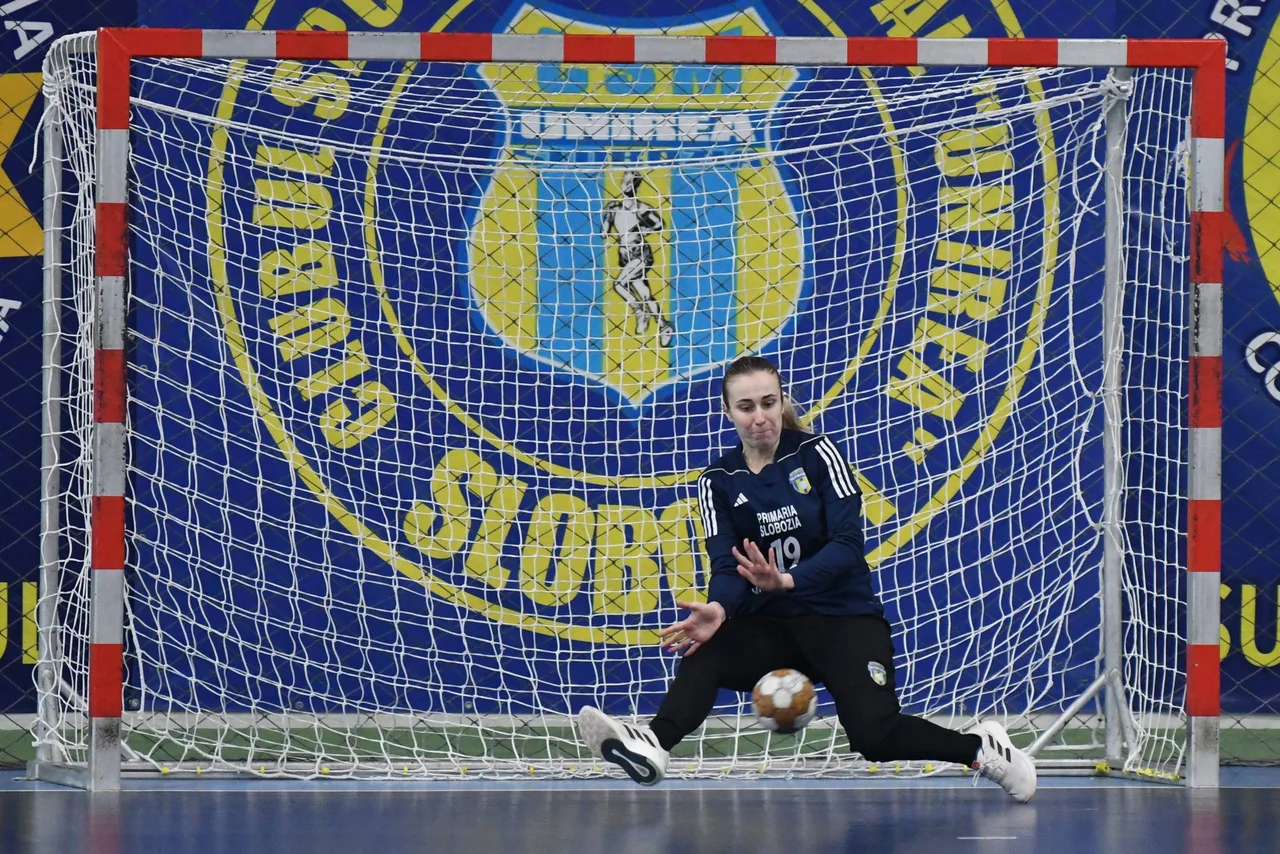 Portarul CSM Unirea se aruncă după o minge joasă, în poarta cu sigla clubului în spate.