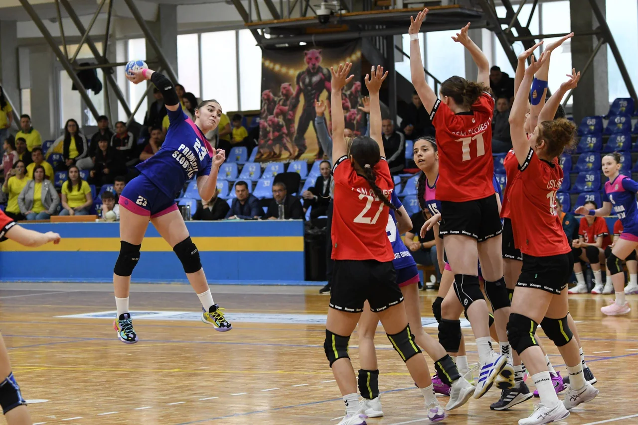 O junioară a CSM Unirea Slobozia aruncă la poartă din săritură peste zidul de apărătoare al CSM Ploiești, la turneul final.