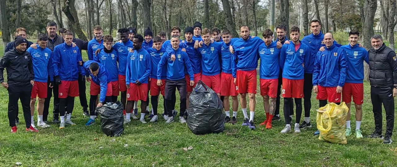 Fotbaliștii și staff-ul Unirii Slobozia în poză de grup în parc, cu sacii de gunoi strânși în față.