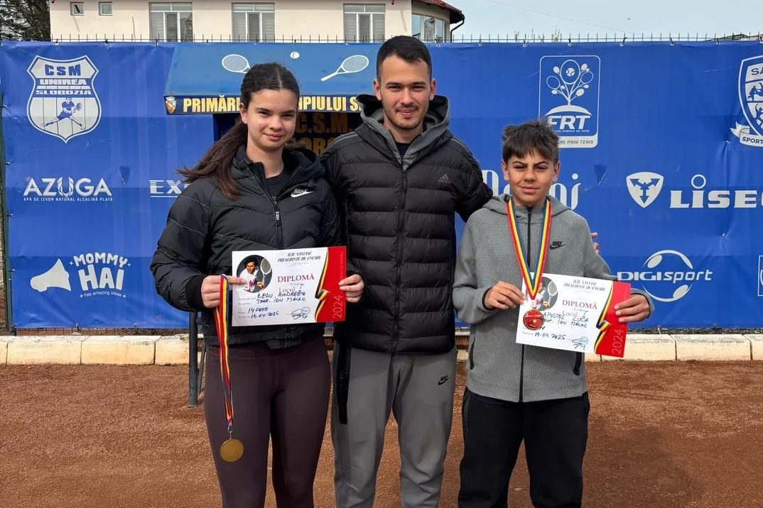 Andreea Dedu și Luca Apostol, cu diplome și medalii de la trofeul „Ion Țiriac”, alături de antrenor pe terenul de tenis.