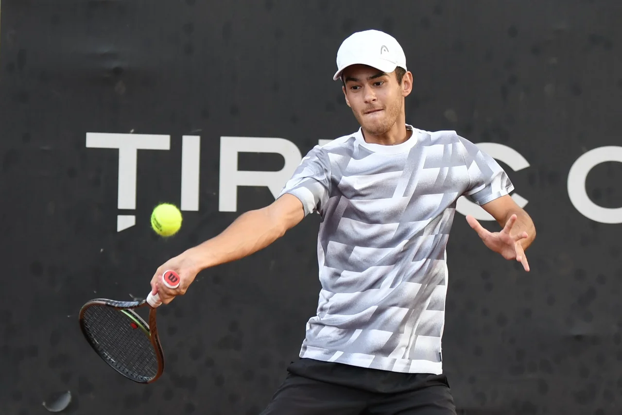 Ștefan Andreescu lovește din forehand, cu privirea pe minge, la un turneu de tenis pe zgură.