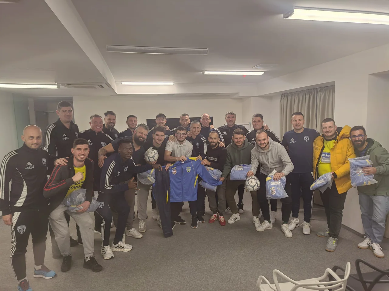 Fotografie de grup cu fotbaliștii Unirea Slobozia, staff-ul și suporterii care au primit echipament și mingi.